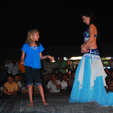 a kid having fun with a belly dancer